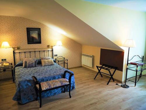 a bedroom with a bed and a table and a piano at Hotel y Casona El Carmen in Perlora