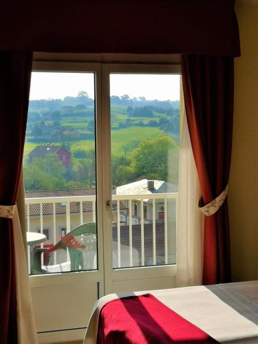 a bedroom window with a view of a balcony at Hotel y Casona El Carmen in Perlora