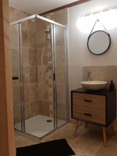 een badkamer met een douche en een wastafel bij Le Havre de Gaïa in Charnècles