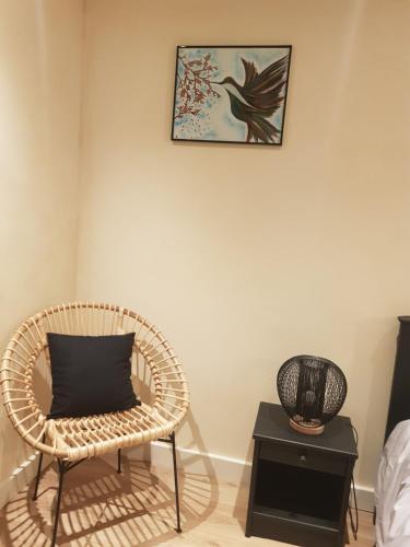 a room with a chair and a bird picture on the wall at Le Havre de Gaïa in Charnècles