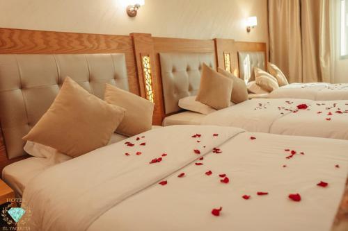 a bedroom with two beds with red roses on the sheets at El Yacouta in Tetouan