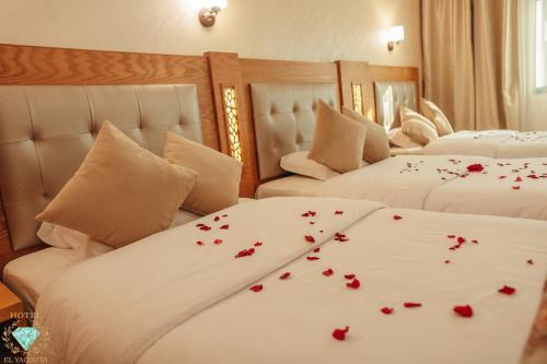 a bedroom with two beds with red roses on the sheets at El Yacouta in Tétouan