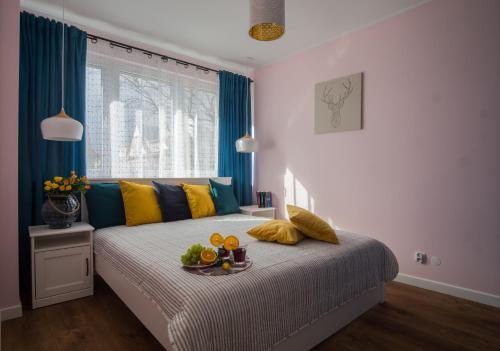 a bedroom with a bed with a tray of fruit on it at Song`s Apartment in Sopot