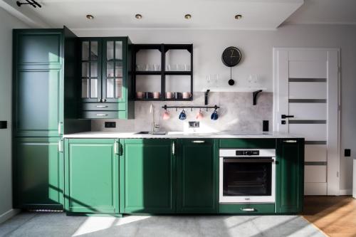 a kitchen with green cabinets and an oven at Song`s Apartment in Sopot