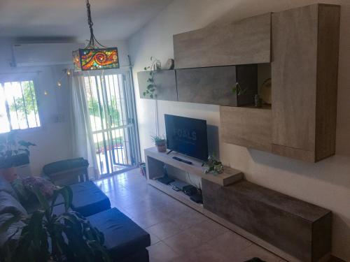 uma sala de estar com um sofá e uma televisão em Casa con pileta Aeropuerto Circunvalación Kempes Quorum -cambio oficial- em Córdoba