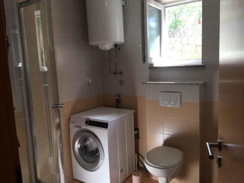 a small bathroom with a washing machine and a toilet at Apartment in Klimno/Insel Krk 38204 in Klimno