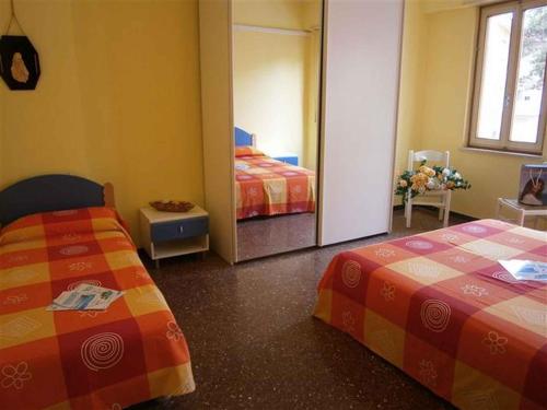 a bedroom with two beds and a mirror at Two-Bedroom Apartment in Bibione VIII in Bibione