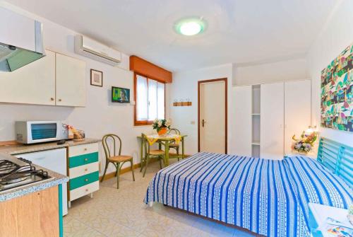 a kitchen and a bedroom with a bed and a table at Holiday home in Bibione 24390 in Bibione