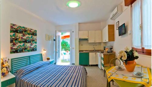 a bedroom with a bed and a table and a kitchen at Holiday home in Bibione 24390 in Bibione