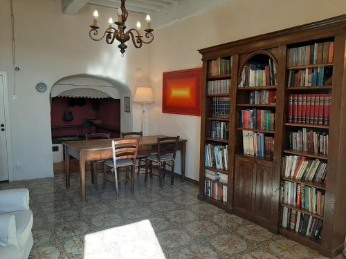 ein Esszimmer mit einem Tisch und Bücherregalen mit Büchern in der Unterkunft Belvilla by OYO Cennini in Montecastelli