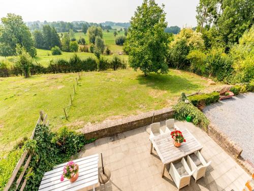 a patio with two white chairs and a table with flowers at Magnificent Holiday Home in Sint Martens Voeren with Garden in Berg