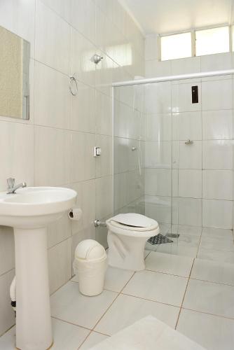 a bathroom with a toilet and a glass shower at Hotel Pousada Jaguariuna in Jaguariúna