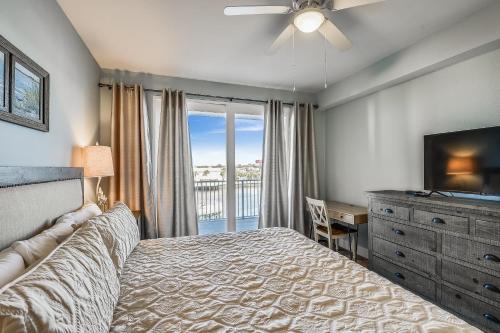 una camera con letto, televisore e cassettiera di Laketown Wharf Resort #226 by Book That Condo a Panama City Beach