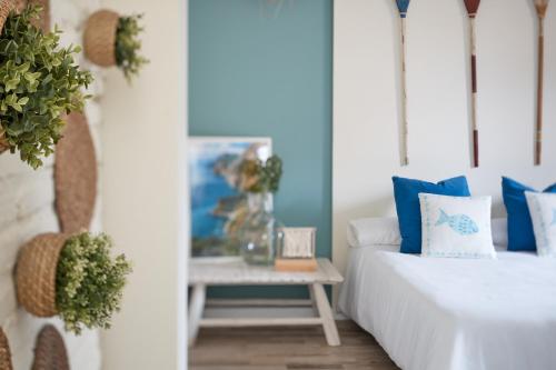 a bedroom with blue and white pillows and a table at Vestal Suites Classic in Cambrils