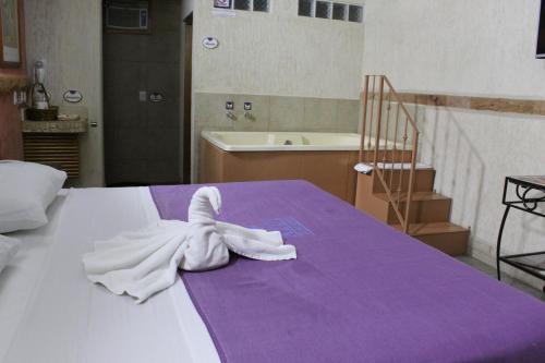 a white towel on a bed with a bathroom at Azul Turquesa in Cuernavaca