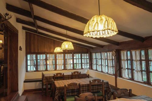 a dining room with a table and chairs and chandeliers at Hotel el Patio de Monterrey in Huaraz