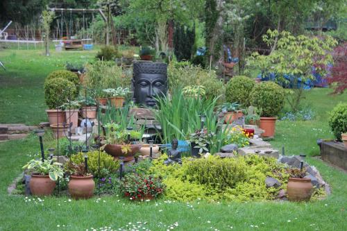 een tuin met planten en een standbeeld in het gras bij Apartment Ramersdorf in Bonn
