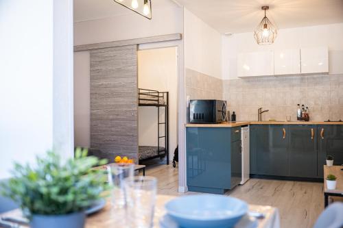 - une cuisine avec des armoires bleues et une table dans une pièce dans l'établissement Le Cosy Babylone, à La Grande Motte