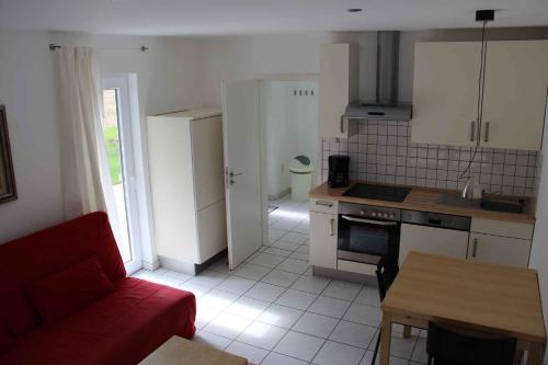 a living room with a red couch and a kitchen at Apartment Rambin 2 in Rambin