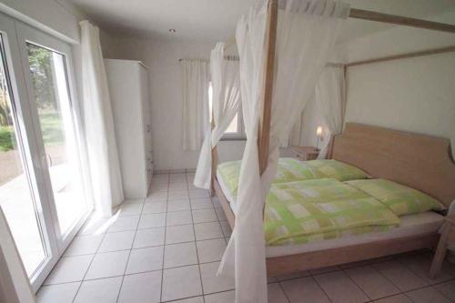 ein Schlafzimmer mit einem Himmelbett in der Unterkunft Apartment Rambin 2 in Gurvitz
