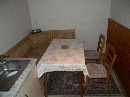 eine Küche mit einem Tisch, 2 Stühlen und einem Waschbecken in der Unterkunft Apartment Zirkow 6 in Schmacht