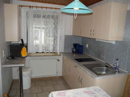 eine kleine Küche mit einem Waschbecken und einem Fenster in der Unterkunft Apartment Zirkow 6 in Schmacht