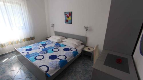 a bedroom with a bed with a blue and white comforter at Apartment Malinska,Krk, Primorje-Gorski Kotar 8 in Vantačići