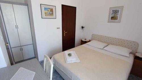 a small bedroom with a bed and a table at Apartment Malinska,Krk, Primorje-Gorski Kotar 10 in Vantačići