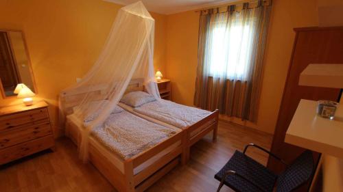 a bedroom with a bed with a mosquito net at Apartment Malinska, Krk 14 in Sveti Vid-Miholjice
