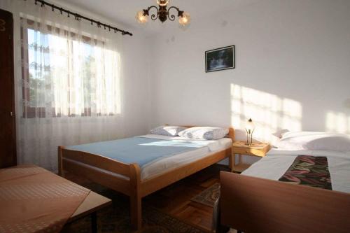 a bedroom with two beds and a window at One-Bedroom Apartment Silo near Sea 6 in Šilo
