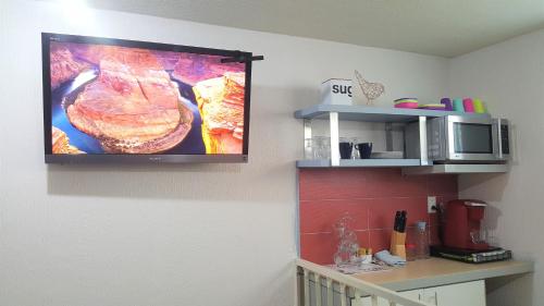 a television hanging on a wall in a kitchen at Hospedaje Tolantongo in Cardonal