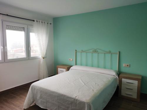 a bedroom with a large bed and a window at Casa A Colorada cerca de la playa de Mar de Fora in Fisterra