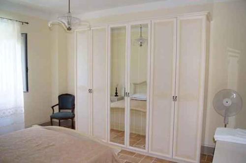 een slaapkamer met witte kasten, een stoel en een bed bij Apartment Umbertide 2 in Niccone