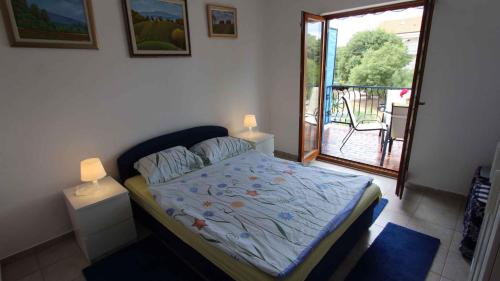 a bedroom with a bed with a view of a balcony at Apartments in Malinska/Insel Krk 14421 in Sveti Anton