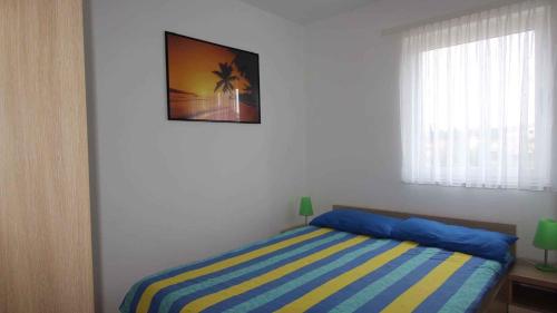 a bedroom with a bed and a picture on the wall at Apartment in Malinska 30 in Vantačići