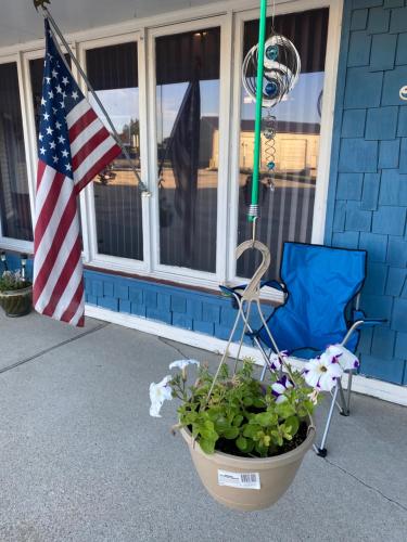 an american flag and a chair and a flag at Burr Oak Motel in Algona