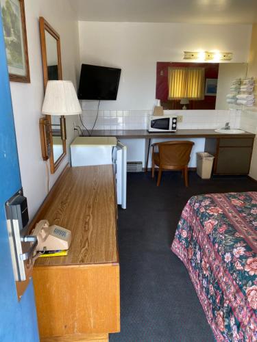 a small hotel room with a bed and a table at Burr Oak Motel in Algona