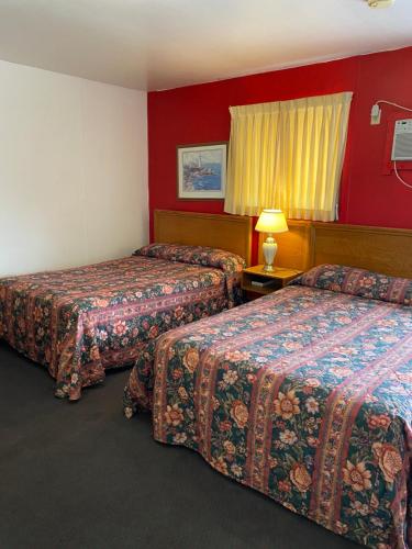 two beds in a hotel room with red walls at Burr Oak Motel in Algona