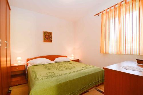 a small bedroom with a bed and a window at Apartment Vinkuran 6 in Vinkuran