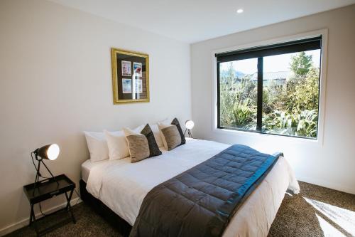 a bedroom with a large bed with a large window at Minaret Ridge - Family Friendly - Sleeps 8 - Mountain Views - Close to Lake in Wanaka