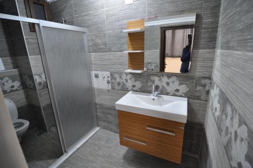 y baño con lavabo, espejo y aseo. en Dekar Apartments, en Trabzon