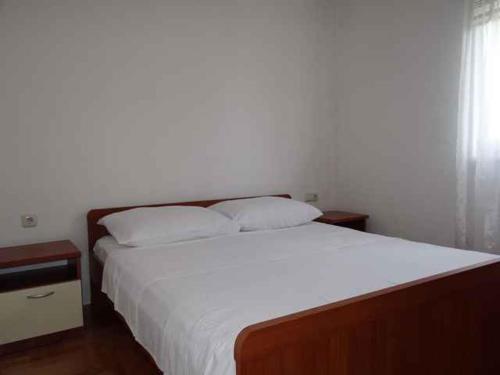 a bedroom with a large bed with white sheets and pillows at Apartment Okrug Gornji 32 in Trogir