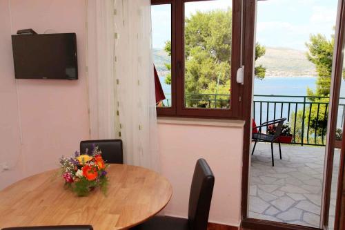 Zimmer mit einem Tisch und einer Vase aus Blumen in der Unterkunft Apartment Okrug Donji 6 in Okrug Gornji