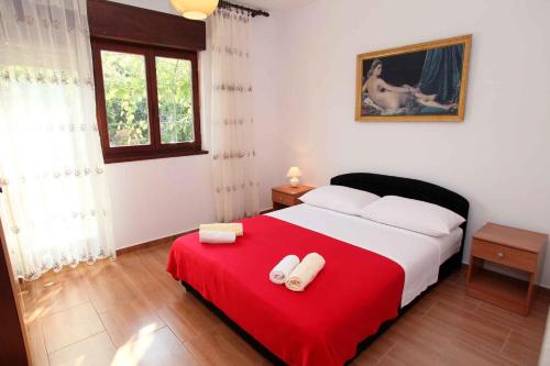 ein Schlafzimmer mit einem großen Bett mit einer roten Decke in der Unterkunft Apartment Okrug Donji 6 in Okrug Gornji