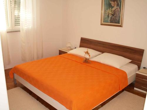 sypialnia z łóżkiem z pomarańczowym kocem w obiekcie Apartment in Zadar/Zadar Riviera 7970 w mieście Smirić