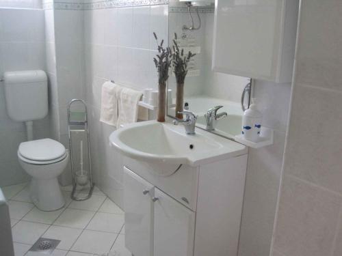 biała łazienka z umywalką i toaletą w obiekcie Apartment in Zadar/Zadar Riviera 7970 w mieście Smirić