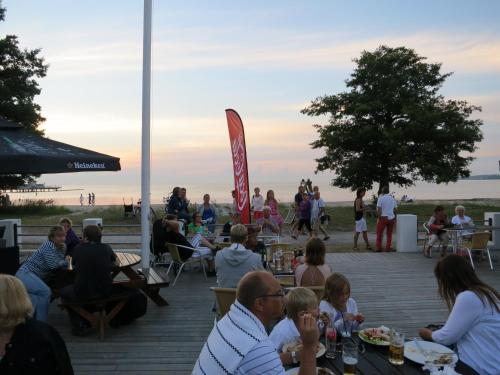 a group of people sitting on a deck at the beach at Strandbaden Köpingsvik in Köpingsvik