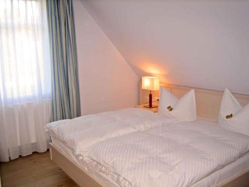 a white bed in a room with a window at Holiday home in Prerow (Ostseebad) 2650 in Prerow