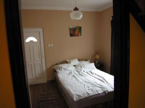 - une chambre avec un lit blanc et une porte blanche dans l'établissement Holiday home in Balatonmariafürdo 19426, à Balatonmáriafürdő