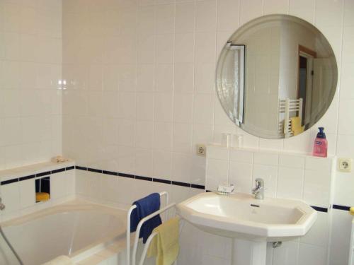 ein Badezimmer mit einem Waschbecken, einer Badewanne und einem Spiegel in der Unterkunft Apartment in Dierhagen (Ostseebad) 2646 in Dändorf